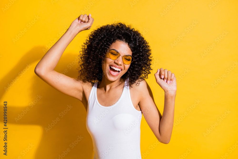 Wall mural Photo of happy afro american woman dance relax weekend holiday wear glasses isolated on vivid yellow color background