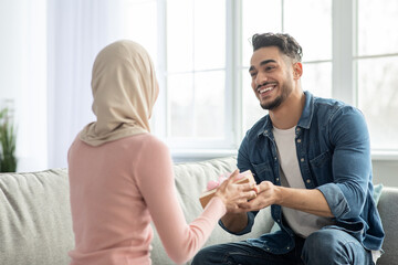 Handsome middle-eastern guy giving his girlfriend present