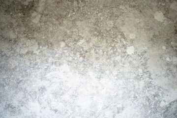White dirty dusty plain floor surface in a renovated building covered with dust from grinding and painting the walls. White dirty monochrome background.
