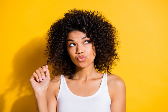 Portrait Of Adorable Dark Skin Lady Arm Fingers Play With Hair Curls Look Empty Space Isolated On Yellow Color Background