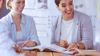 Obraz premium Young people studying with books on desk. Beautiful women and men working together.