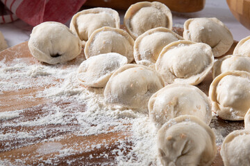 Preparation dumplings on wooden board with flour.Russian food.