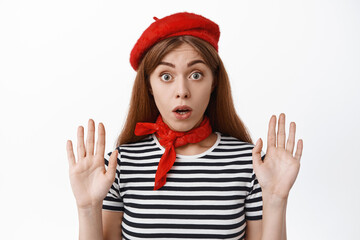 Cute french girl raising hands up as if leaning on invisible glass, pantomime actor performing,...