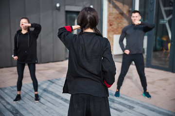 Obraz premium View from behind of wushu coach with hand before face