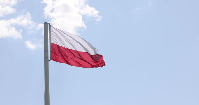 Polish flag on the mast. Beautiful Polish flag waving in a strong wind.