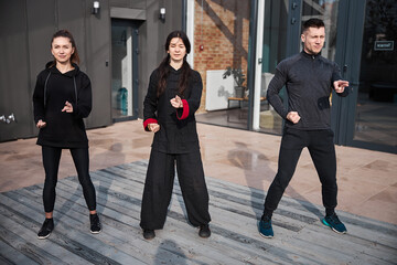 Three kung fu athletes pointing ahead with fingers