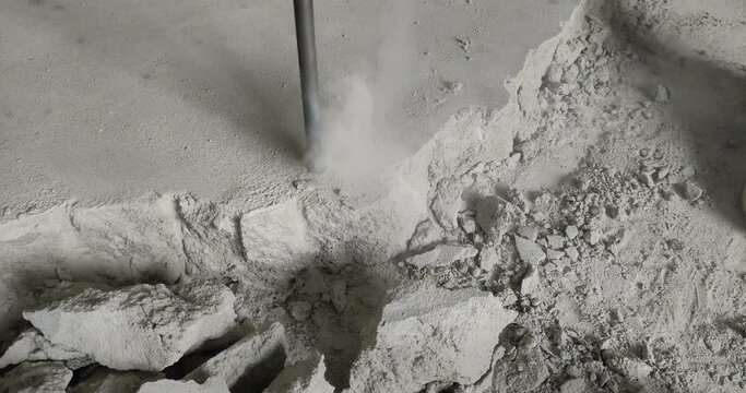 A builder dismantles a perforator drill breaks the concrete floor at a construction site	
