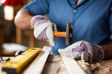Close up of carpenter working on wood craft at workshop.