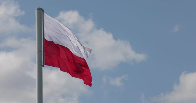 Polish flag on the mast. Beautiful Polish flag waving in a strong wind. Slow motion