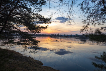 River sunset quiet landscape view. Evening by the river. Pine trees against the background of the evening landscape.