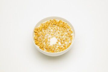 wheat flakes with milk in a white cup on a white background