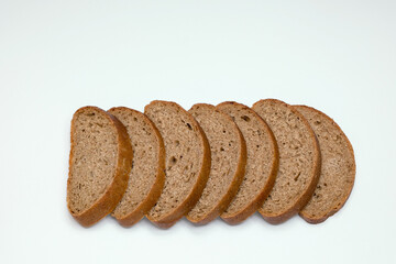 pieces of black bread from coarse flour on a white background