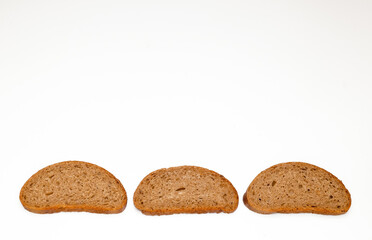 pieces of black bread from coarse flour on a white background