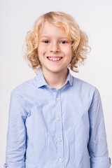 Vertical image of a preteen caucasian blonde boy isolated over white background