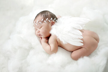 Naked little Chubby Newborn sleeping with Angel wings showing baby's bottom. Angelic Cupid laying...