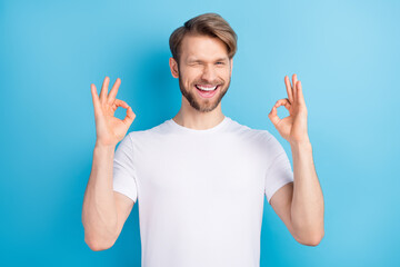 Photo portrait of man wearing white t-shirt showing okay sign both hands winking isolated vivid...