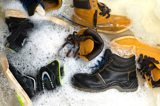 many different dirty shoes are in the bathroom filled with water
