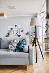 Grey sofa and floor lamp in the interior.