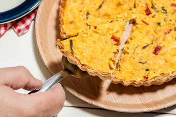 Serving an exquisite portion of homemade corn cake or quiche with onion, red bell pepper and chives. Healthy and natural food.