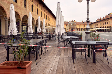 Fototapeta premium Tables and chairs in an outdoor restaurant in Vigevano (Lombardy, Northern Italy), during Covid closure.