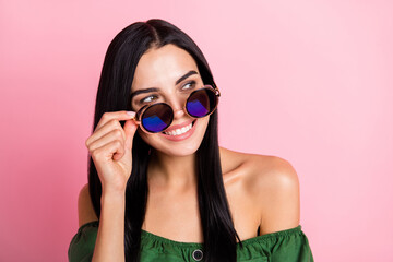 Photo of young cheerful girl happy positive smile wear sunglass dream look empty space isolated over pastel color background