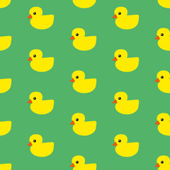 Yellow rubber ducks with orange beaks and black eyes on green background, seamless pattern 