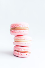 Beautiful macarons standing on top of each other in pink against a white background. Gift to a loved one