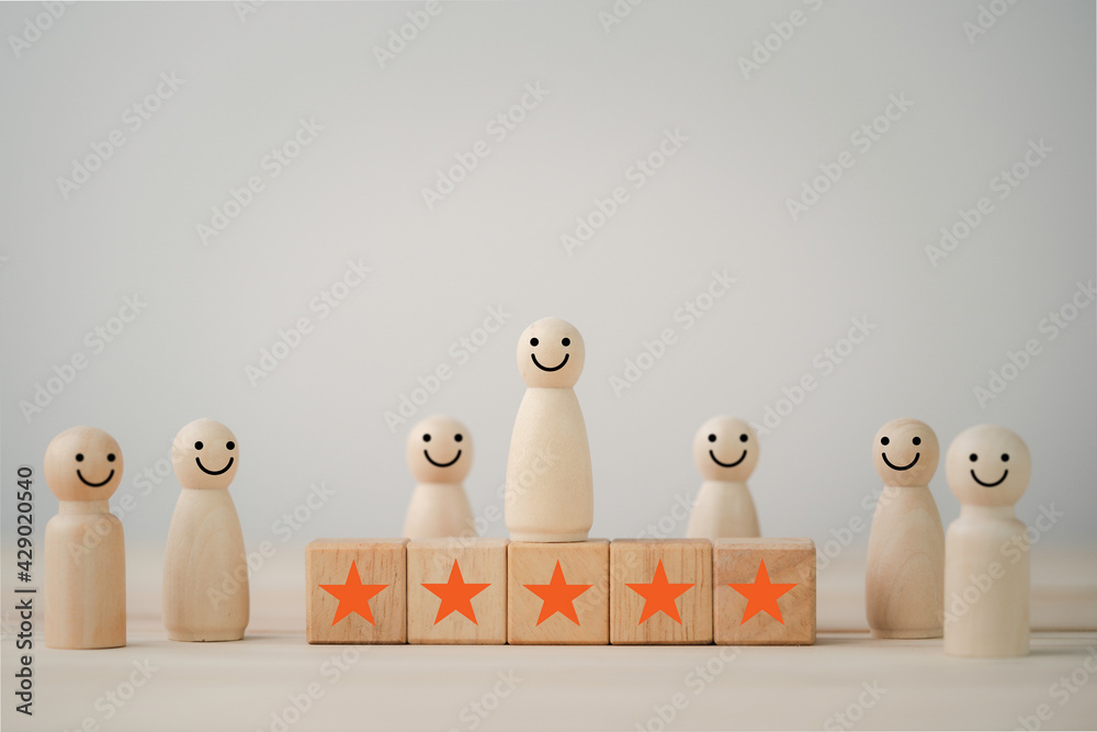 Aufkleber smiley face on wooden miniature figure with five star on wooden cube for the best customer evaluatio