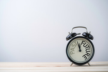 Alarm clock running for change from past to future on wooden table with copy space.