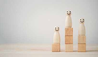 The winner first and second runner of smiley human figure wooden cube standing on podium with copy...