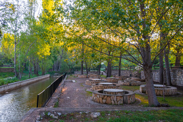 Public park and picnic area, with nice stone seats, by the river, early in the morning.
