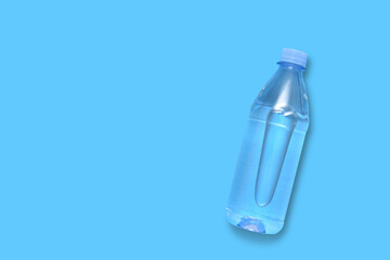 Plastic bottle with water on a blue background with copy space