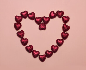 Close up heart shaped red candy on a pink background