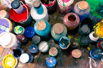 pots full of color mixes on the floor of an artist's studio