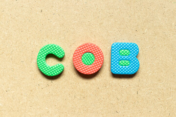 Fototapeta na wymiar Foam alphabet letter in word COB (abbreviation of close of business) on wood background
