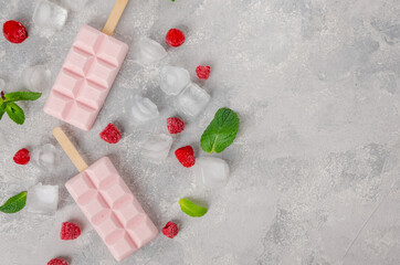 Homemade raspberry ice cream or popsicles decorated green mint leaves and frozen berries with ice...