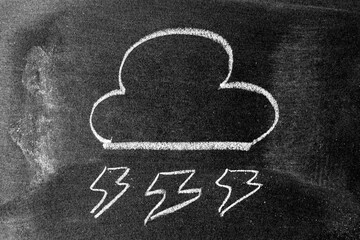 White color chalk hand drawing in cloud with thunder shape on blackboard or chalkboard background
