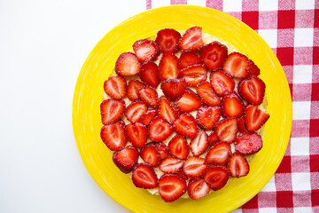 Bright and delicious strawberry cake on a red napkin in a cage