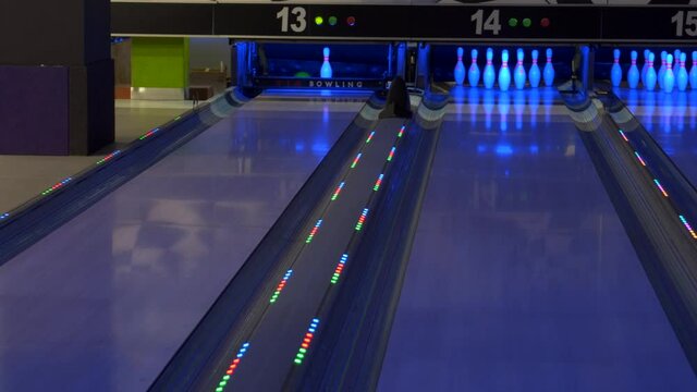 Bowling game. A bowling ball traveling down the lane and knocks down pins.