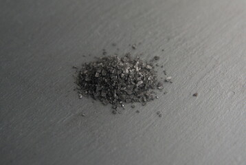 Black  salt pile, on grey stone background