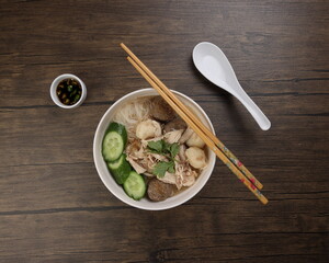 Clear white rice vermicelli beehoon noodle soup with chicken beef meat ball shredded cucumber in...