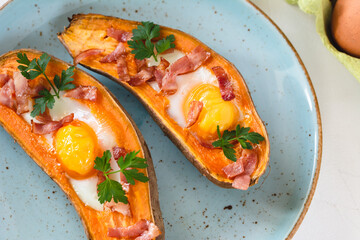 Baked sweet potato with fried egg, bacon and parsley.