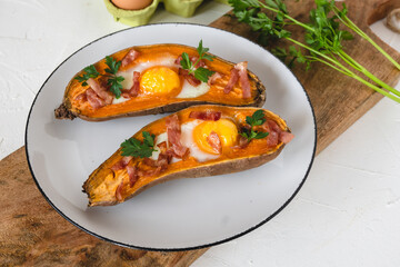 Baked sweet potato with fried egg, bacon and parsley.