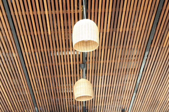 Rattan lamp hanging on the slatted ceiling.