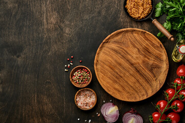 Fresh tarragon. Branch of fresh herb seasoning and cooking products, tomatoes, peppers, onions and olive oil on black concrete background. Cooking Background. Top view.