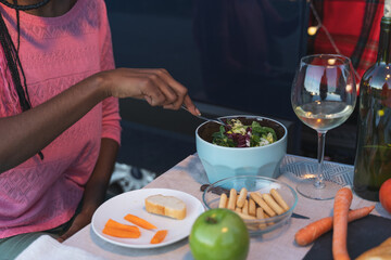 African girl picking salad at a camping table next to a van