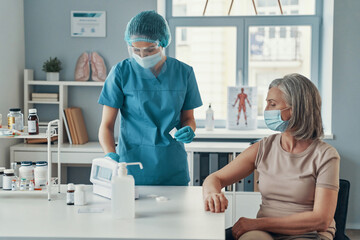 Young female nurse making vaccination 