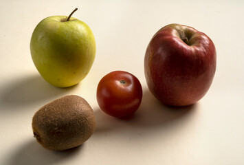 apple tomato and kiwi on a wite background