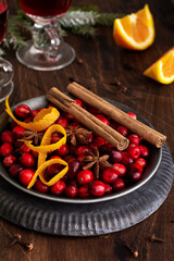 Ingredients for making mulled wine with cranberries. Orange, cinnamon, cranberry berries, cloves, anise and sugar. Christmas atmospheric retro concept. Place for text