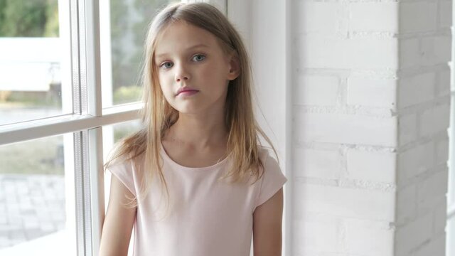 Fashionable Cute kid child girl model portrait. Little child smiling and looking at camera near window. People, beauty, children, kids lifestyle concept